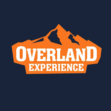 Logo der Overland Experience mit Bergmotiven und orangefarbener Schrift auf dunklem Hintergrund.